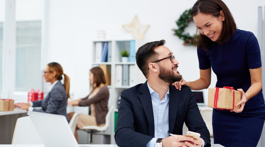woman giving her coworker a christmas gift