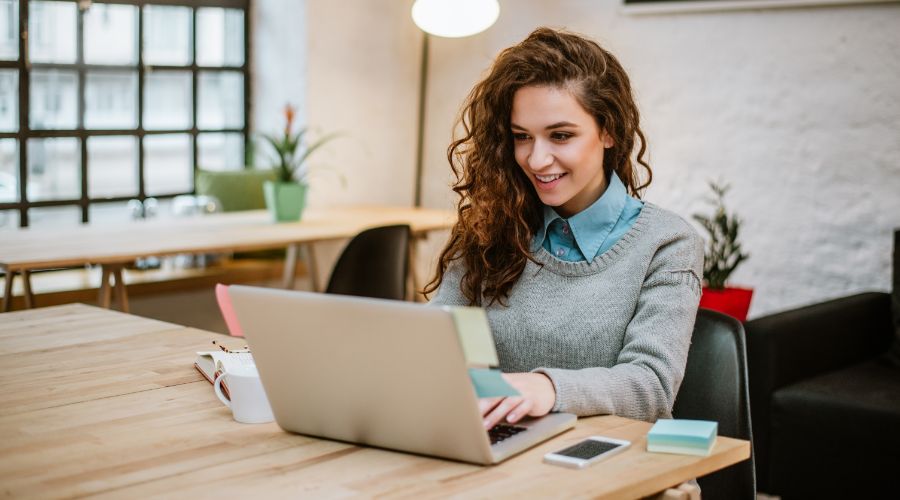 Business woman running payroll on a laptop