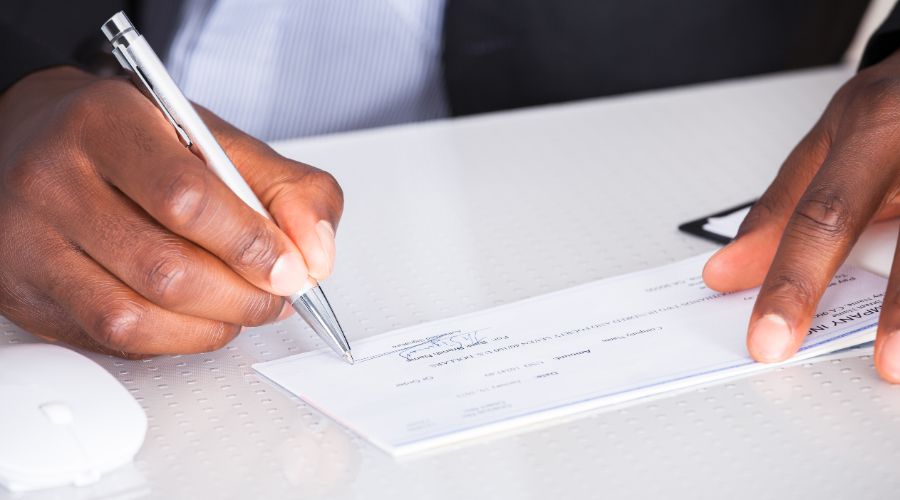 close-up of small business owner signing paycheck